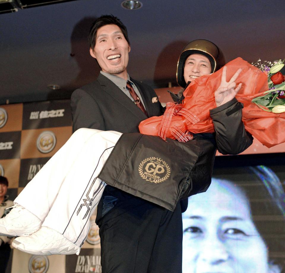 　プレゼンターの篠原信一（左）にお姫様だっこされ笑顔を見せる山崎智也