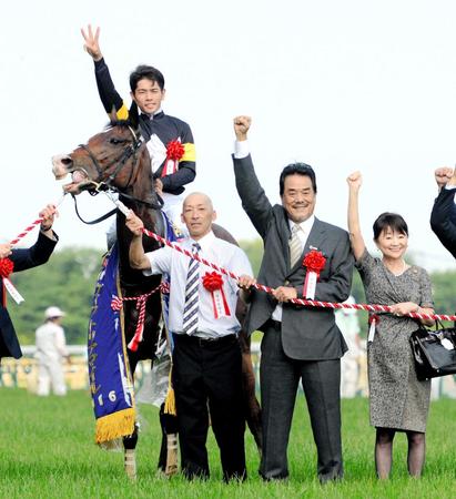 　Ｇ１３勝目となったストレイトガールをたたえ、３のポーズを見せる戸崎圭と笑顔でガッツポーズの廣崎オーナー（右から２人目）