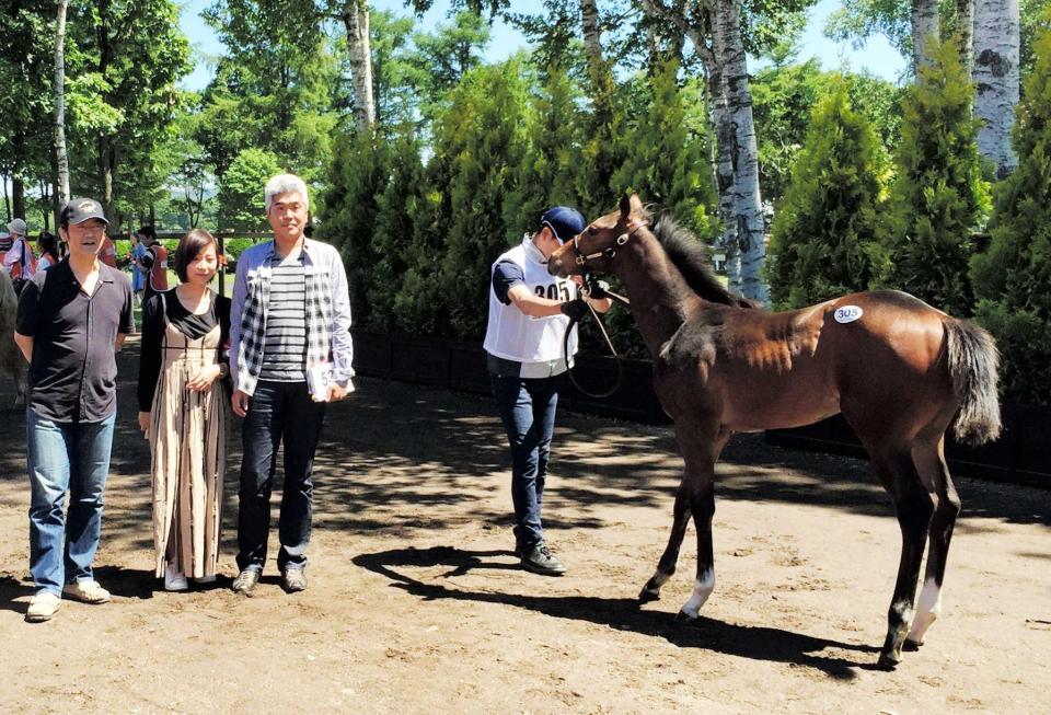 　落札したジャスタウェイ産駒と写真に収まる大和屋暁氏（左から３番目）