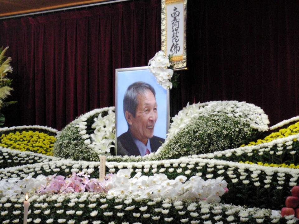 　亡くなった武邦彦さんの祭壇には遺影と多くの花束が添えられた