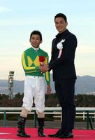 プレゼンターの松田丈志と握手する四位洋文（左）＝阪神競馬場（撮影・山口登）