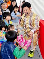 じゃんけん大会の賞品を子どもたちに配布する田前義守