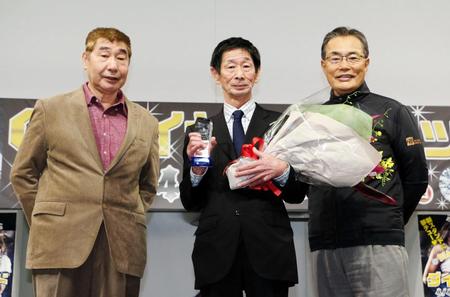 表彰式でトロフィーを手にする関忠志氏（中央）。左は漫画家の蛭子能収氏、右は作詞家の喜多條忠氏