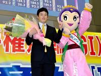 優勝報告会で奈良競輪マスコットキャラクターの飛天ちゃん（右）から花束を受け取る三谷竜生