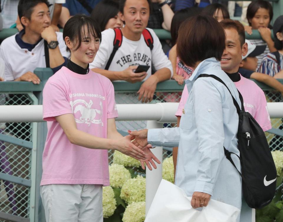 　ファンと握手する藤田騎手（左）