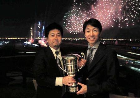 　１６年ＵＡＥダービーをラニで制し、優勝カップを武豊（右）とともに手にする長谷川さん