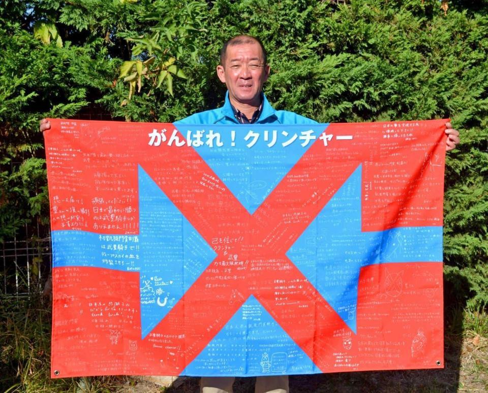 　日本のファンから寄せられた応援メッセージ入りのフラッグを手にする宮本師