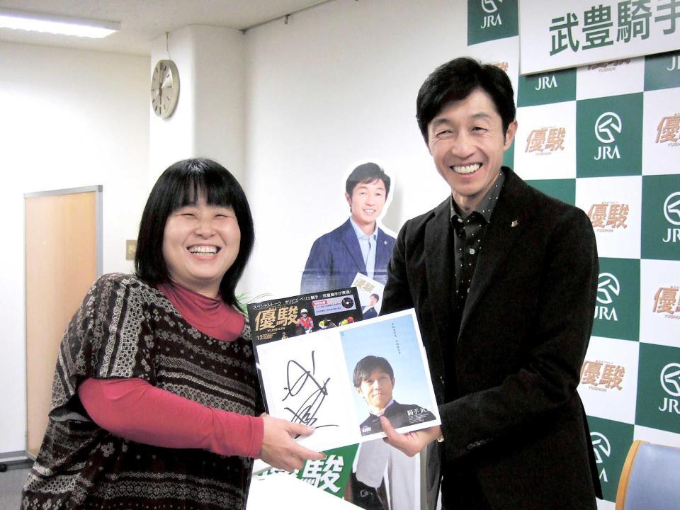 　「優駿」創刊９００号イベントでファンにサイン色紙を手渡しする武豊