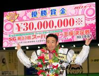 ３回目の優勝を成し遂げ、賞金ボードを掲げて喜ぶ永井大介