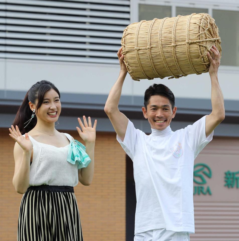 　夏の新潟リーディングを獲得し、米俵を掲げる戸崎圭（右）。左は土屋太鳳