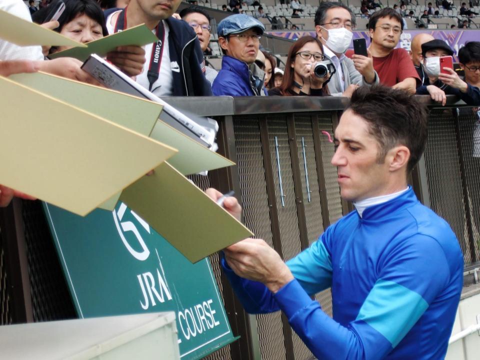 21日の東京７Ｒをソーラーフレアで勝ち、ファンにサインをするＣ・スミヨン騎手