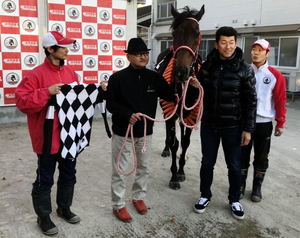 三浦大輔オーナー（右から２人目）も駆けつけ、矢作師（右から３人目）ら厩舎関係者とリーゼントロックの“引退式”を行った＝滋賀県の栗東トレセン