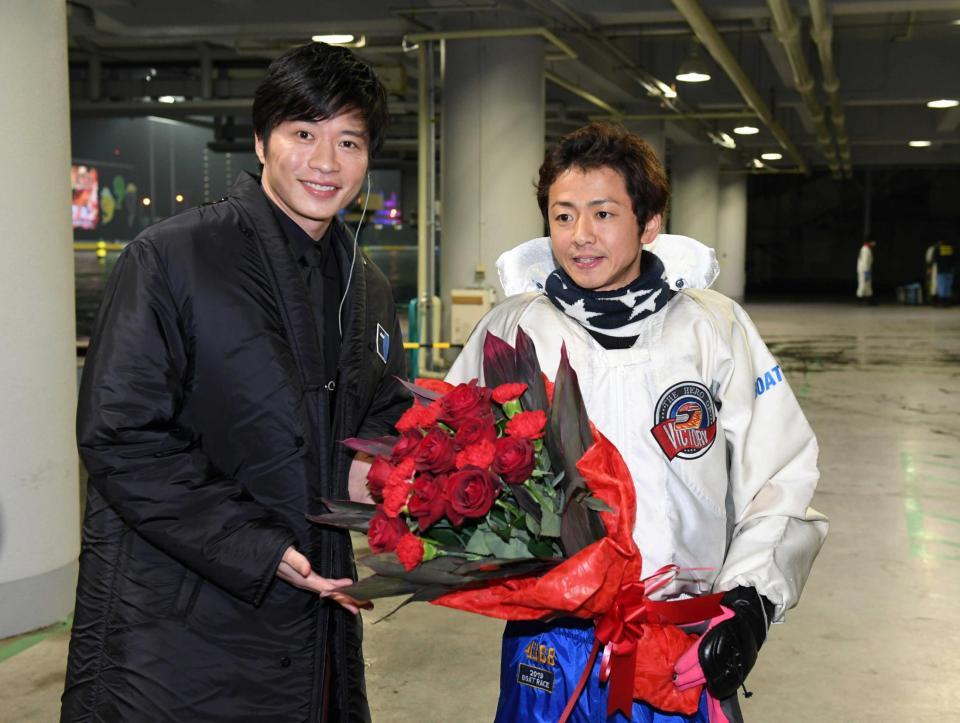 　石野貴之（右）はグランプリを制し田中圭から花束を贈られる