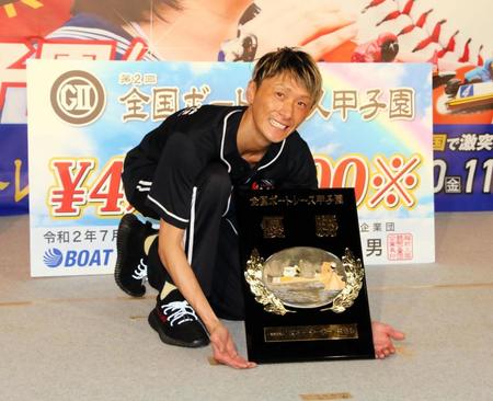 　甲子園の砂を集めるように優勝盾をアピールする峰竜太