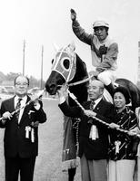 １９７７年のダービーを制したラッキールーラの馬上で手を上げる伊藤正徳騎手と尾形藤吉師（右から２人目）
