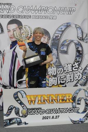 トロフィーを掲げて優勝を喜ぶ前本泰和