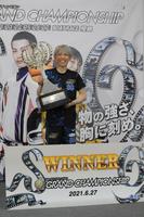 トロフィーを掲げて優勝を喜ぶ前本泰和