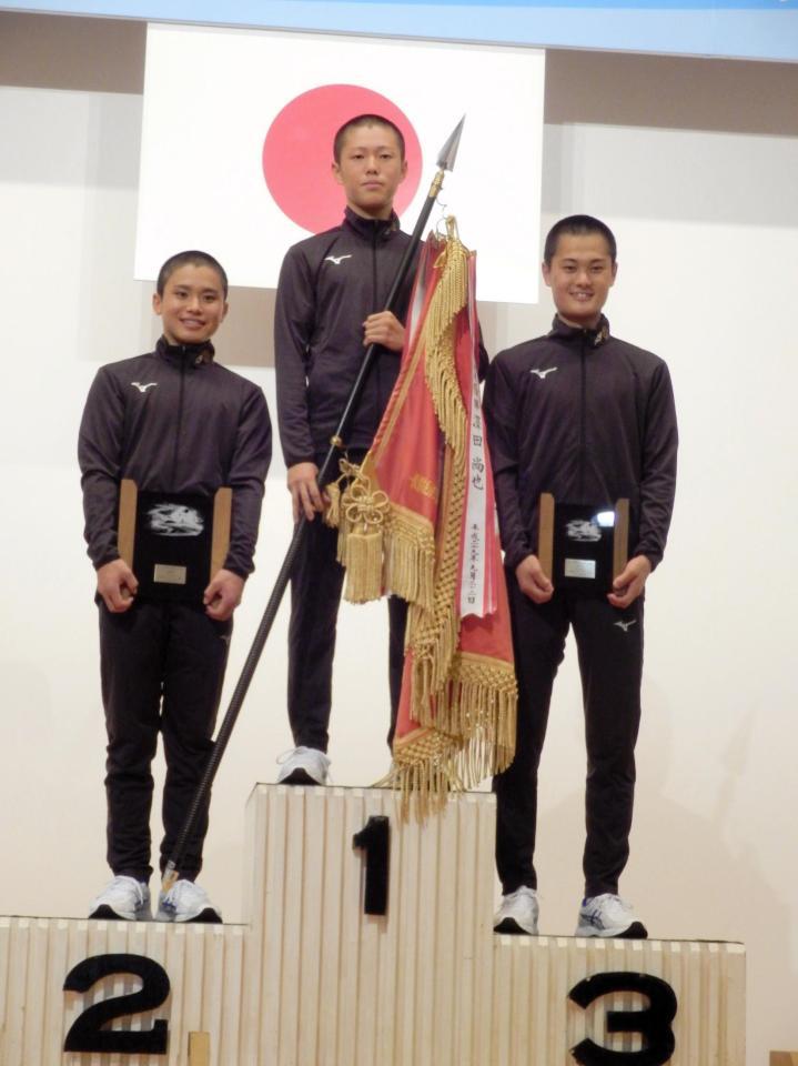 　養成所チャンプ旗を手にする西岡顕心（中央）左は２着の藤原碧生、右は３着の藤田俊祐
