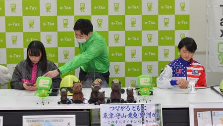 スマホでのｅ-Ｔａｘを体験する永島まなみ（左）と古川奈穂（撮影・石湯恒介）