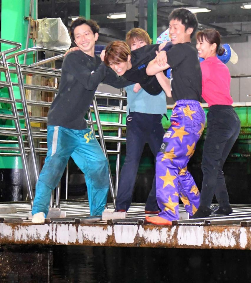 　水神祭で仲間たちに投げ込まれようとする遠藤エミ（中央）