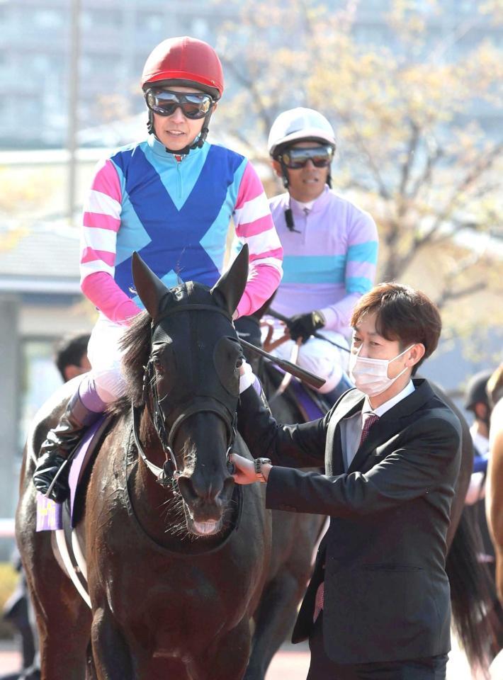 　引き揚げるウォーターナビレラと武豊。右は武幸師