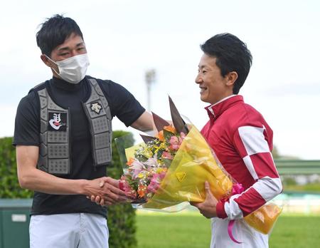　中山グランドジャンプが障害レース１０００回騎乗となり、西谷から花束を手渡される石神（右）＝撮影・三好信也