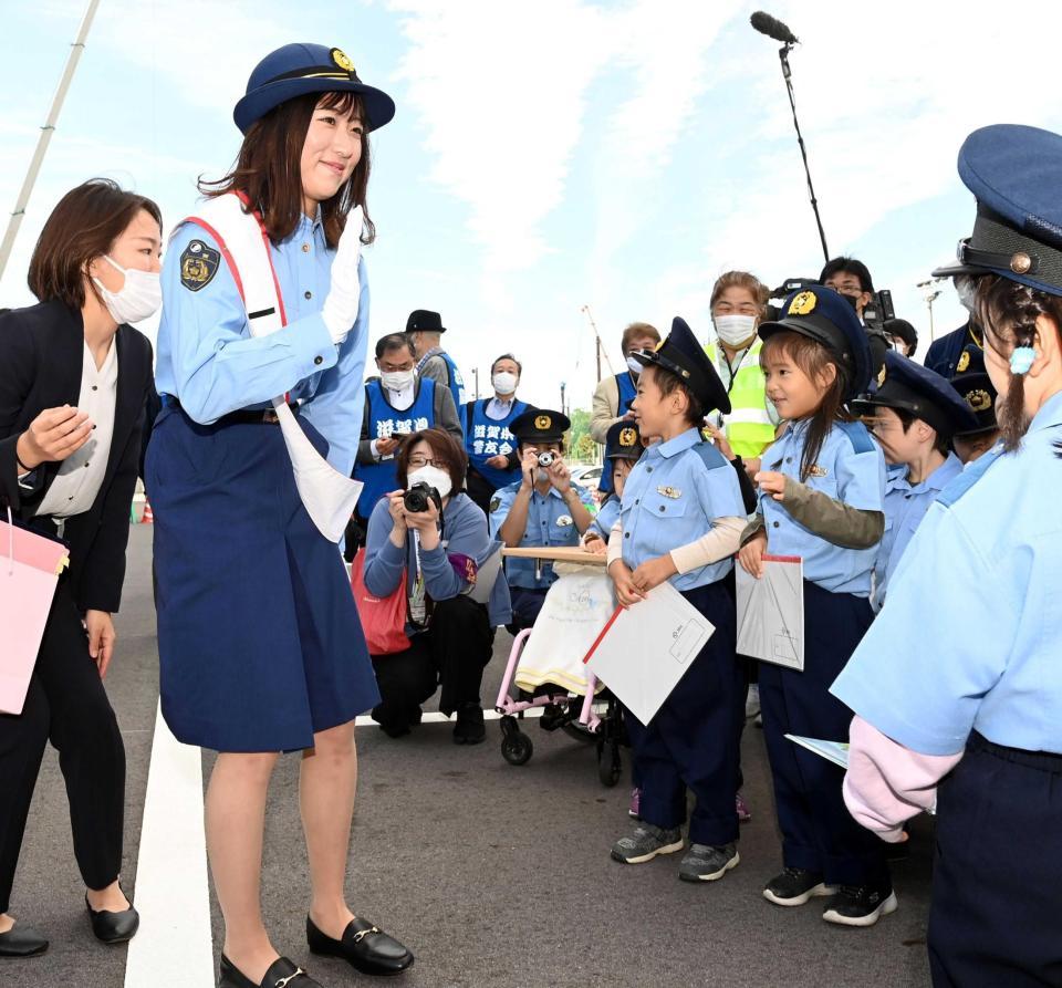 　（写真説明）一日警察署長として、笑顔で子どもたちに手を振る今村聖奈（撮影・山口登）