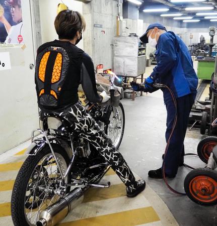 　レース後、右ハンドルを整備員にあぶってもらい修正する森且行