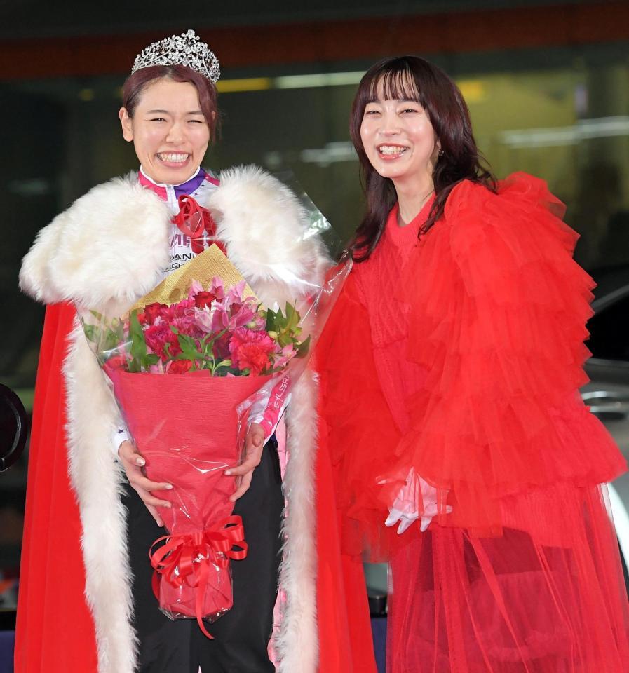 　ヒグチアイ（右）から花束を渡されて笑顔を見せる佐藤水菜