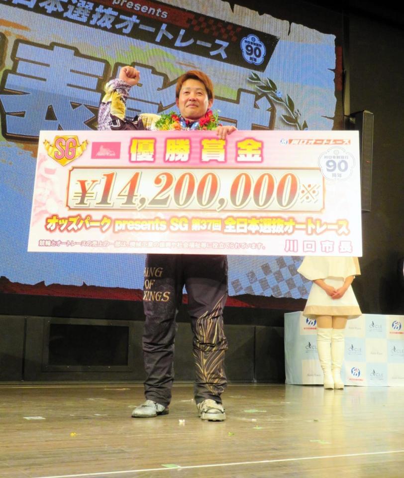 　賞金ボードを手にガッツポーズをする金子大輔