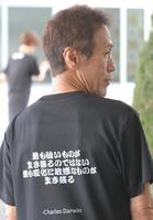 　西島義則のＴシャツの背中にはお気に入りの言葉「最も強いものが生き残るのではない　最も変化に敏感なものが生き残る」が書かれている