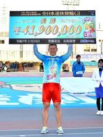 　賞金ボードを高く掲げる脇本雄太