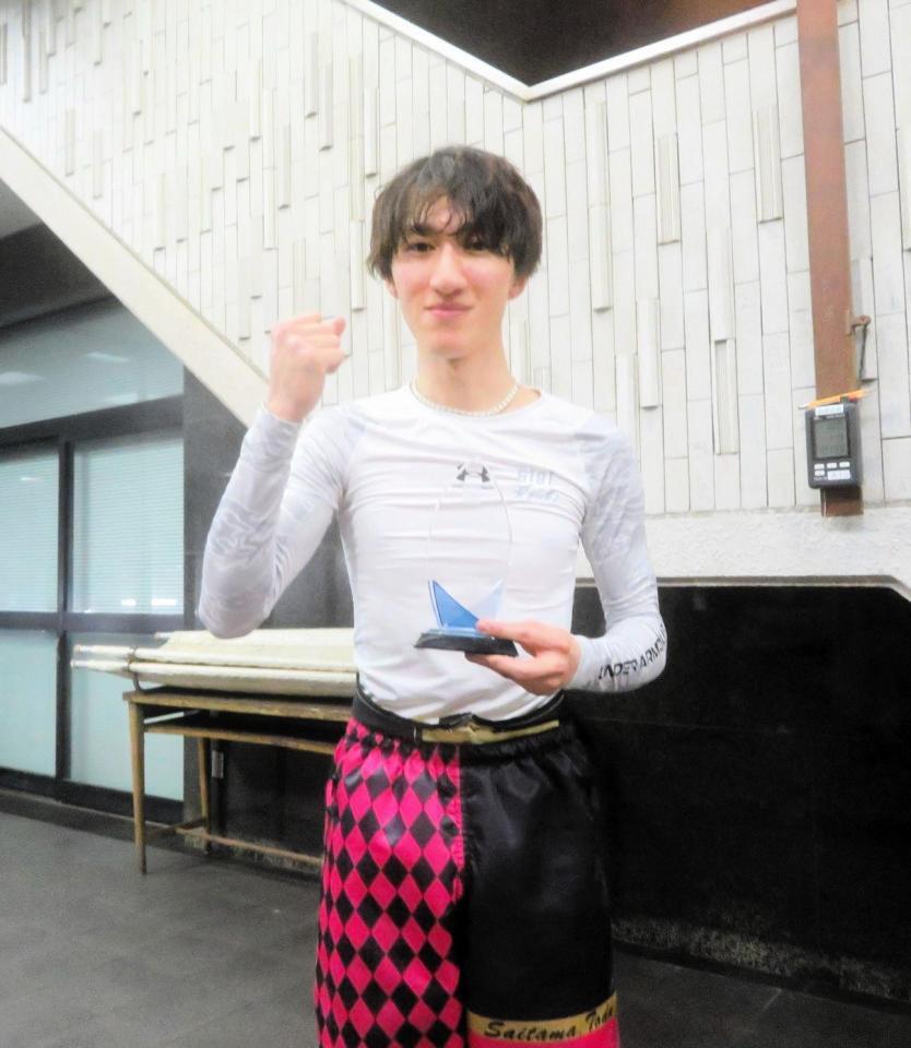 　トロフィーを手にガッツポーズをする飛田江己