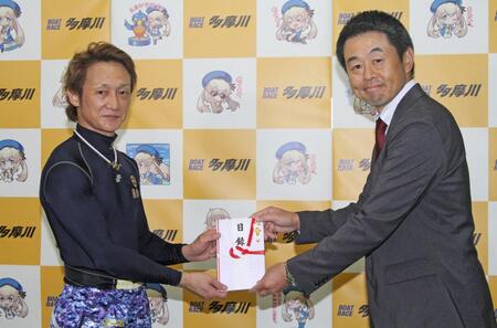　当地４度目のＶを決め、喜多井昭デイリースポーツビジネス局東京営業部長から目録を受け取る赤岩善生（左）
