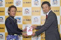 　当地４度目のＶを決め、喜多井昭デイリースポーツビジネス局東京営業部長から目録を受け取る赤岩善生（左）