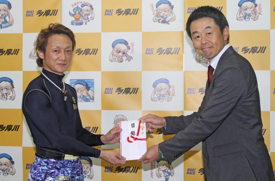 　当地４度目のＶを決め、喜多井昭デイリースポーツビジネス局東京営業部長から目録を受け取る赤岩善生（左）