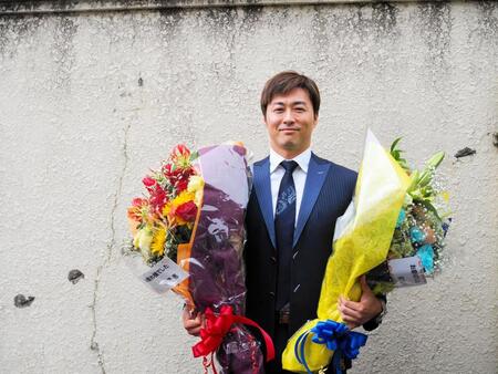 花束を手に笑顔の平原康多