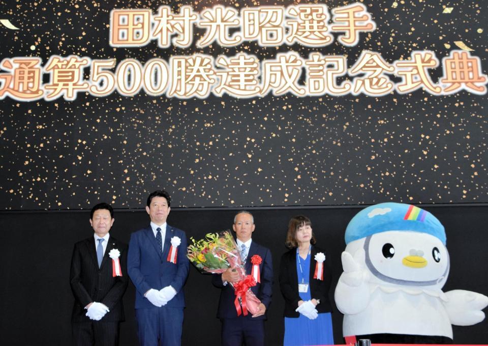 　関係者と記念撮影する田村光昭（中央）