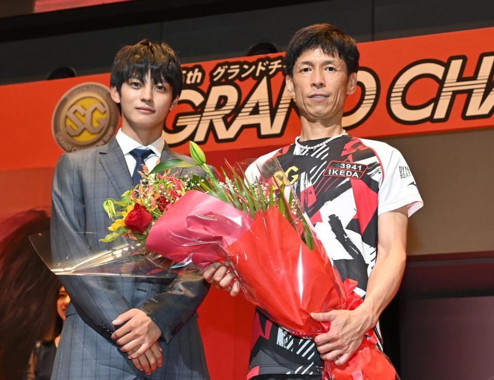 　グランドチャンピオンを制し、表彰式で神尾楓珠（左）から花束を受け取る池田浩二