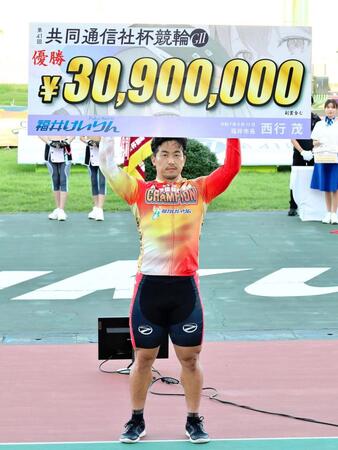 　優勝して賞金ボードを掲げる南修二