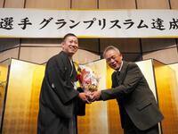 　福井県立科学技術高校自転車競技部元顧問で恩師の辻正男さんから花束をもらう脇本雄太（左）