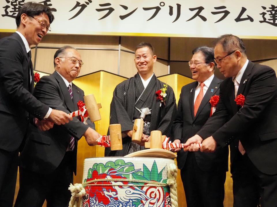 　鏡割りを行う脇本雄太（中央）