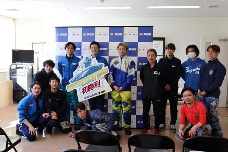 先輩に囲まれて笑顔でボードを手にする熊倉幹太（中央）