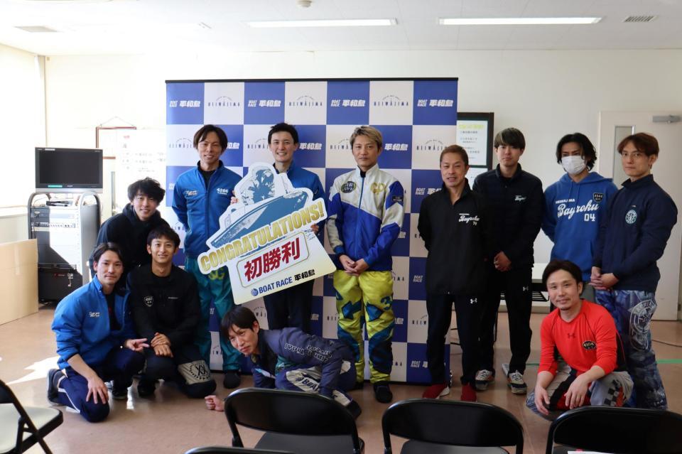 先輩に囲まれて笑顔でボードを手にする熊倉幹太（中央）