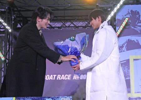 ２０２６新ＣＭキャラクターの町田啓太（左）から花束を手渡される末永和也