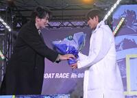 ２０２６新ＣＭキャラクターの町田啓太（左）から花束を手渡される末永和也