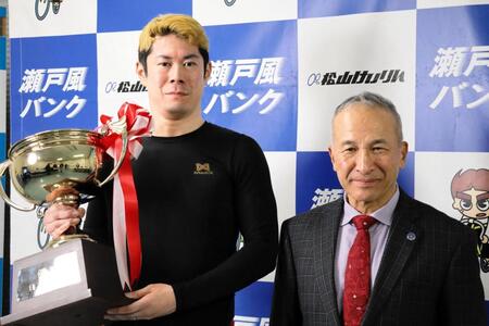 優勝カップを手にする根田空史（左）と本紙評論家・伊藤豊明氏