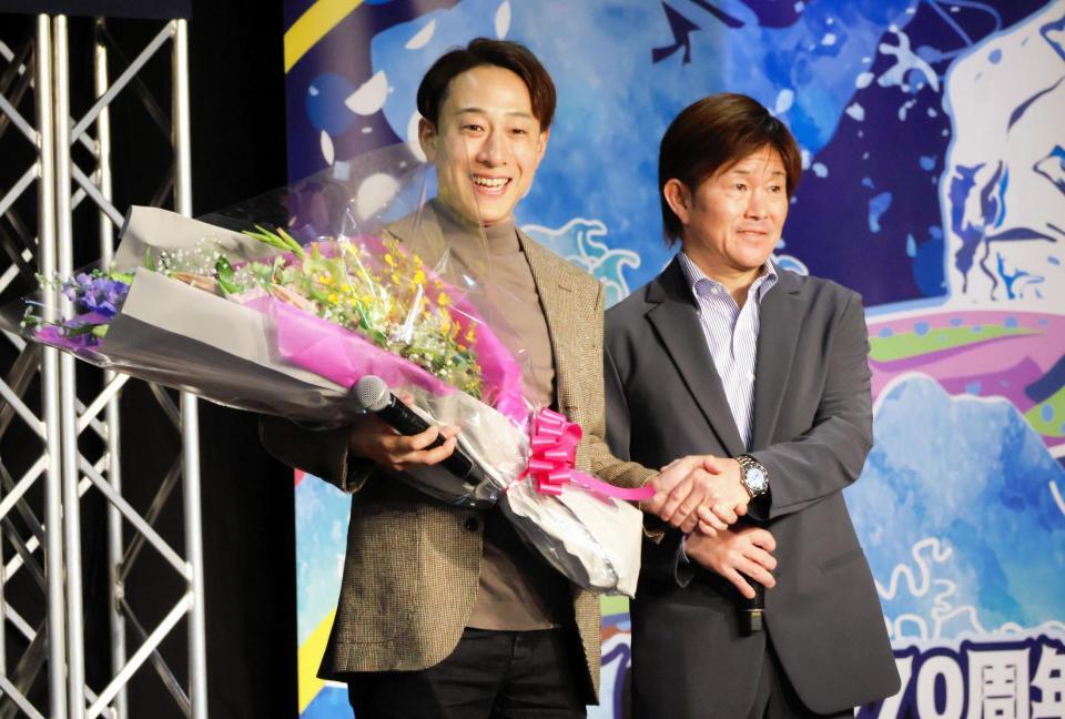 檀上で握手を交わす藤岡佑介調教師（左）と小牧太