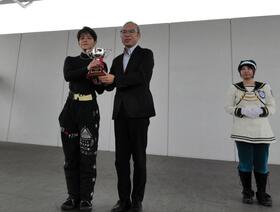 三原崇生デイリースポーツビジネス局局長から優勝カップを授与される高倉和士（左）