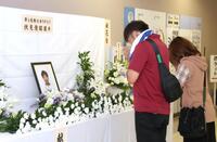 伏見俊昭さんの献花台に手を合わせるファン（撮影・中田匡峻）